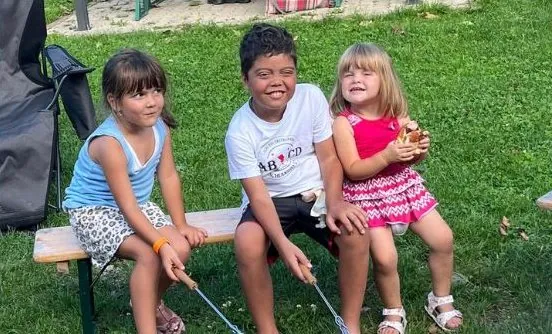 Felix mit zwei Mädchen beim Grillen im Garten